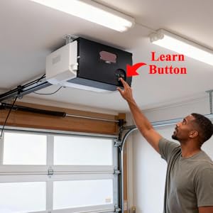 A finger points to the &amp;#34;Learn Button&amp;#34; on a garage door opener motor unit for pairing.