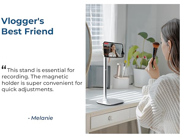 Adjustable phone stand with magnetic holder shown on white desk surface, marketed as 'Vlogger's Best Friend' for content creation.