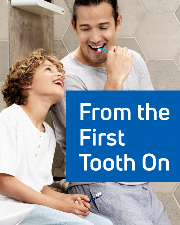 A smiling man and boy brushing their teeth with TePe brushes. Text reads: “From the first tooth on.”