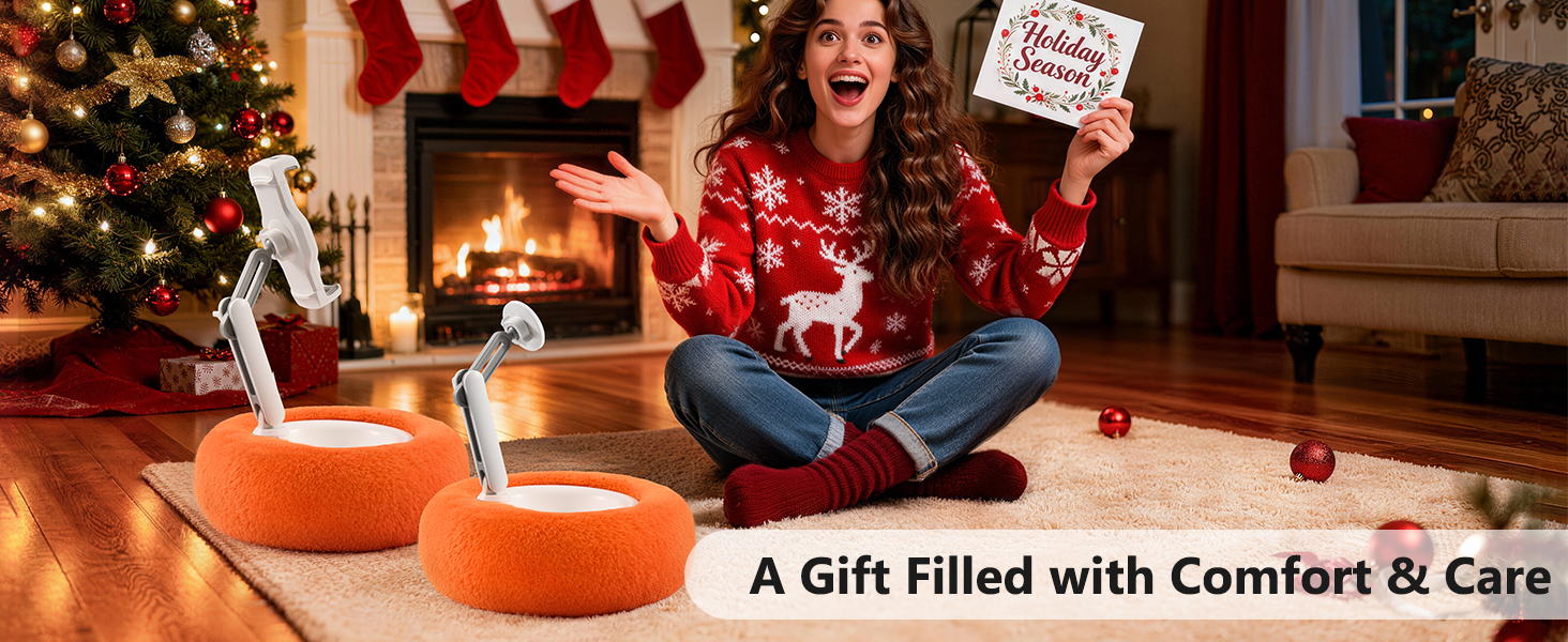 Text reads 'A Gift Filled with Comfort &amp; Care'. Holiday scene with Christmas tree and decorations, featuring an orange circular cushion or ottoman.