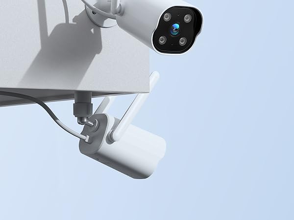 Close-up of a white security camera with multiple lenses mounted on a bracket. The camera has a round shape with four visible camera sensors.