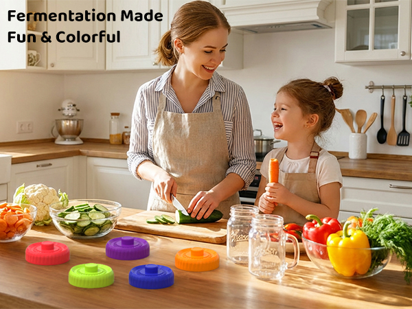 Family making healthy fermented food in kitchen using colorful silicone mason jar airlock lids.