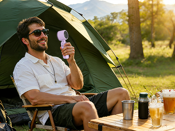 Man camping with purple rechargeable fan outdoors powerful small fan for hot summer days tent