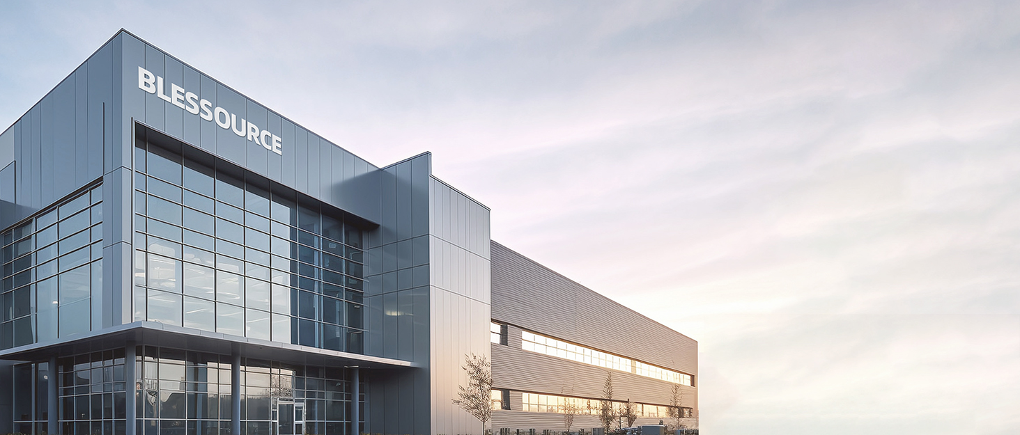 Exterior view of large modern commercial building with glass facade and 'BLK' signage. Parking lot visible in foreground.
