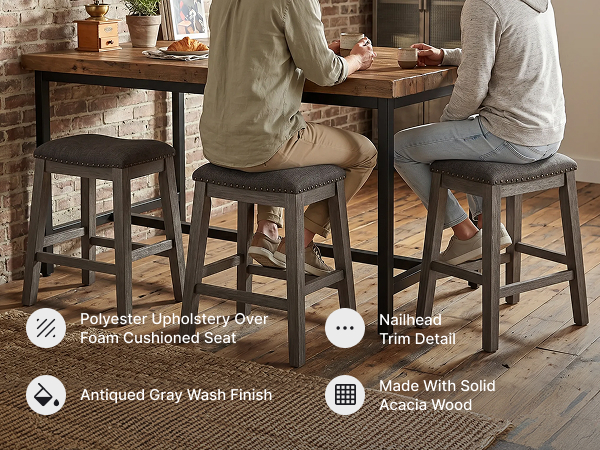 Kitchen island setting with backless counter height bar stools featuring a gray wood finish
