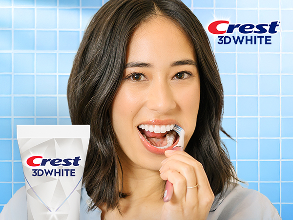 Happy woman brushing her teeth with Crest 3DWhite.