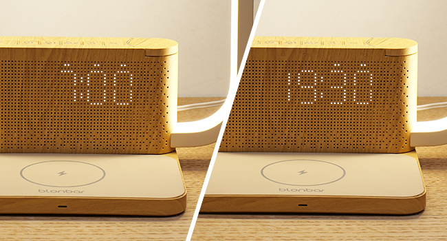 Digital alarm clock with wooden base and LED display. Two images showing different times: 7:00 and 19:30. Clock has a minimalist design with perforated front panel.