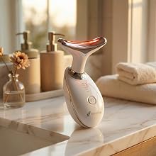 LED skincare device on bathroom counter in warm lighting