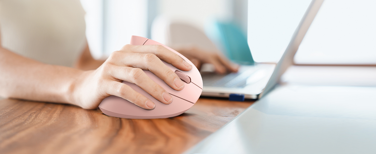 a woman's hand is holding a mouse on a desk.