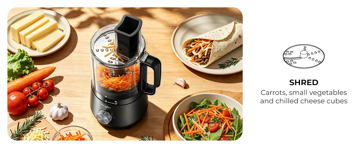 Mini food processor shredding carrots beside cheese, a salad and a filled wrap.