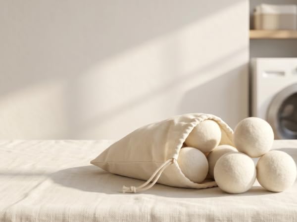 Reusable wool dryer balls stored in a cream cotton bag