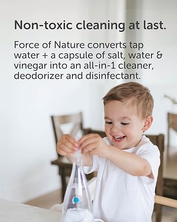 Non-toxic cleaner with smiling toddler holding Force of Nature cleaner in a bright home kitchen.