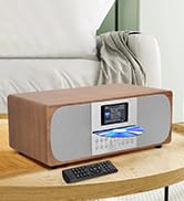 Modern digital radio or audio device with display screen sitting on wooden surface, featuring clean minimalist design.