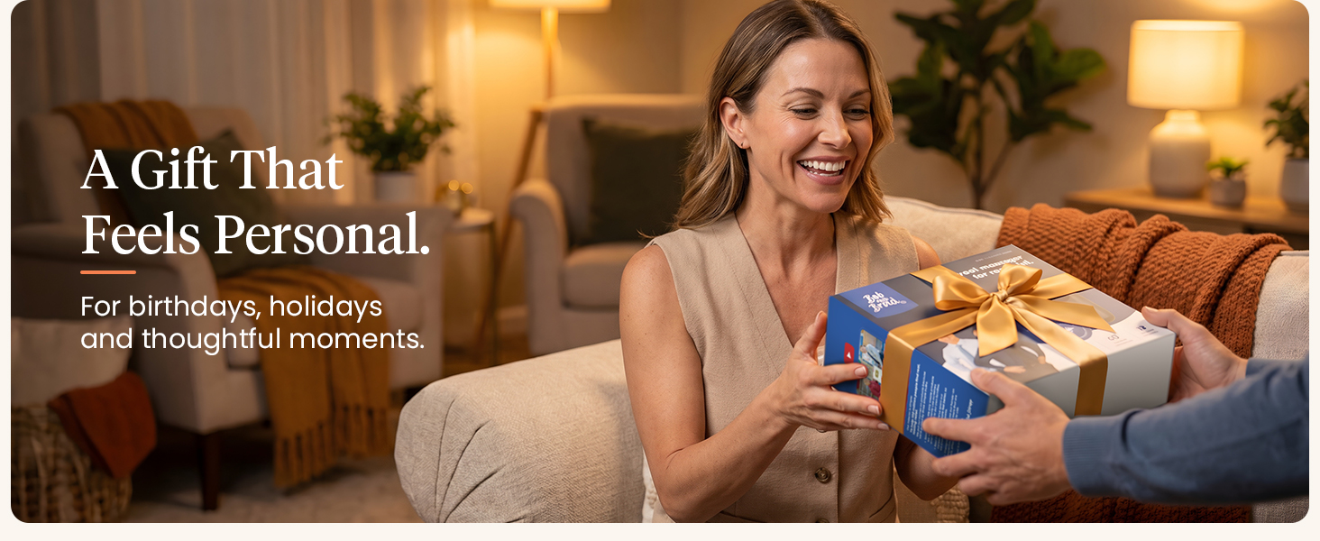 Smiling woman receives a gift-wrapped BOB AND BRAD massage gun in a warm living room.