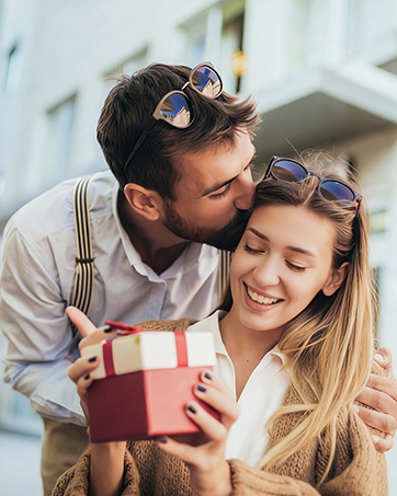 Three connected photos showing a couple enjoying a romantic moment, with a gift box present.