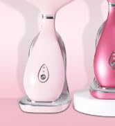 Two teardrop-shaped devices, one white and one pink, with rounded bases. The devices appear to be personal care appliances, possibly facial steamers or humidifiers.
