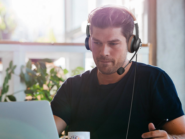 A man wears ARA700 wired headset at work in an office.