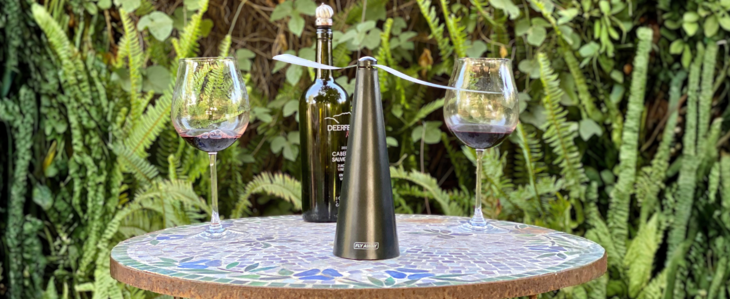 Fly Away fly fan on an outdoor table keeping flies away from glasses during patio dining.