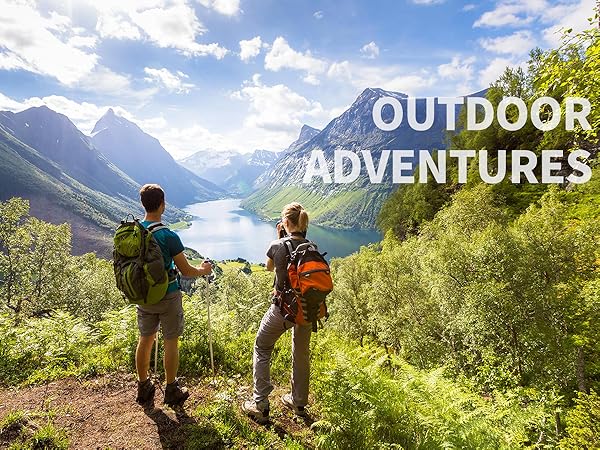 Two hikers with backpacks overlooking a scenic mountain valley. Text overlay reads 'OUTDOOR ADVENTURES' against blue sky and green foliage.