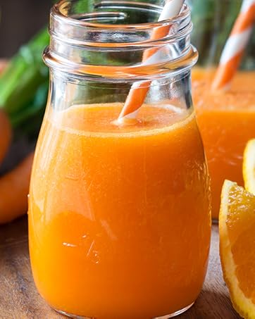 carrot juice in a glass jar with a straw.