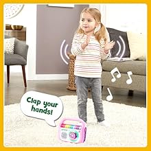 Player makes music and says: Clap your hands! Kid dances and claps her hands with music player.