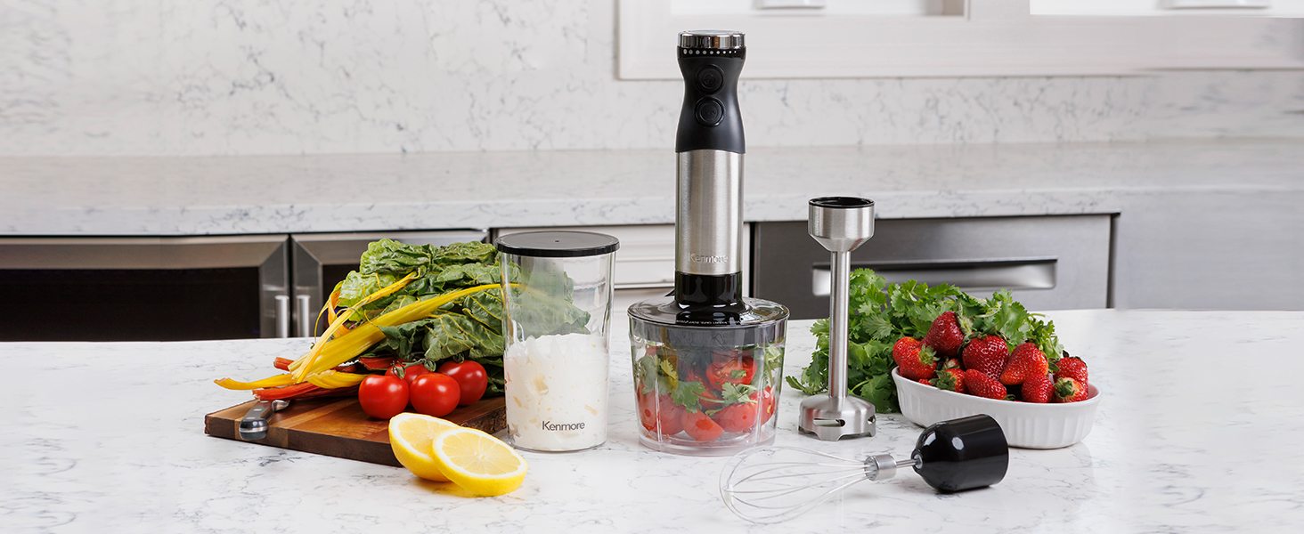 Kenmore hand blender and attachments with food on a marbled white kitchen counter