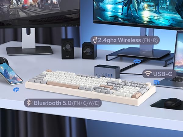 a white desk with a white keyboard and two speakers.