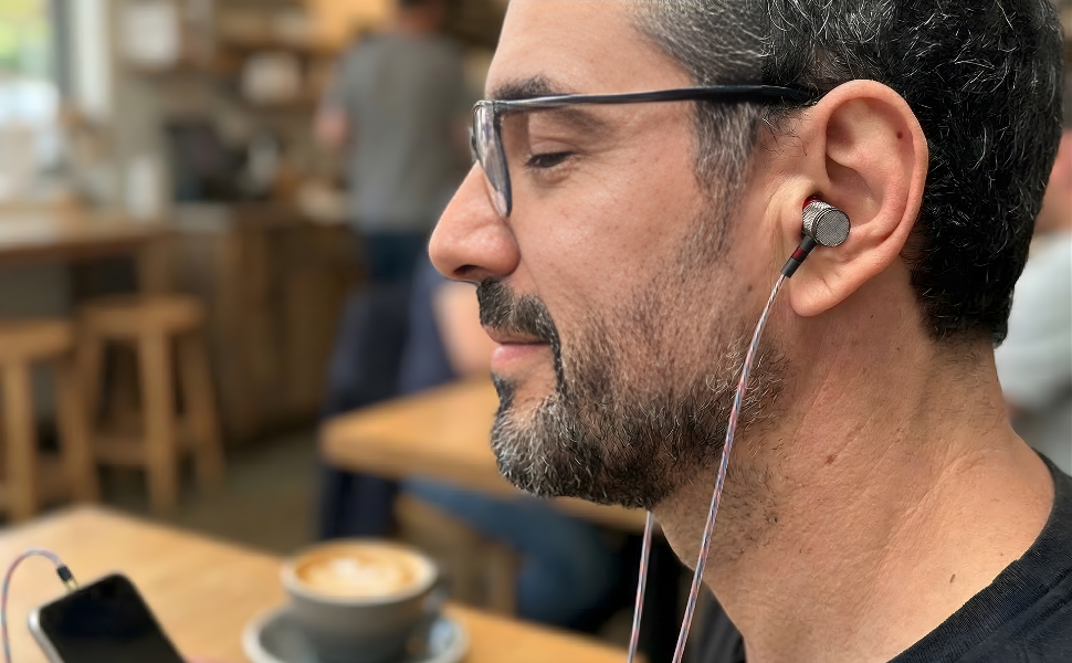A man wearing Betron in-ear wired earbuds
