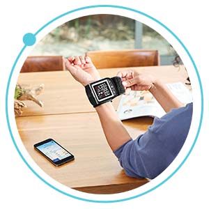 person attaching blood pressure monitor to wrist