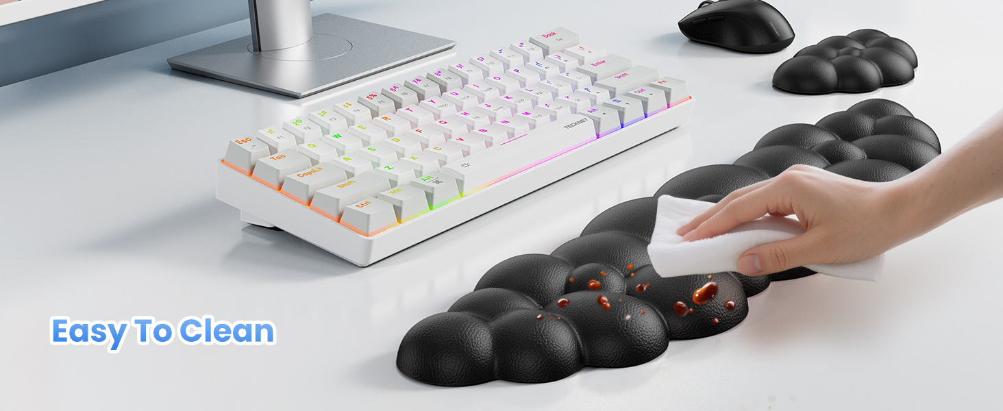 Ergonomic hand rest with bumpy surface being cleaned. White mechanical keyboard with colorful illuminated keys and computer mouse visible in background.