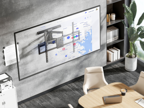 Wall-mounted TV bracket installation shown in modern office setting with bookshelf and plant decor.