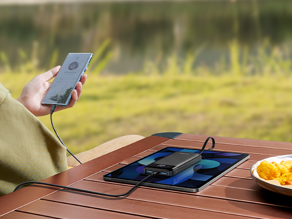 a person is holding a cell phone on a table.