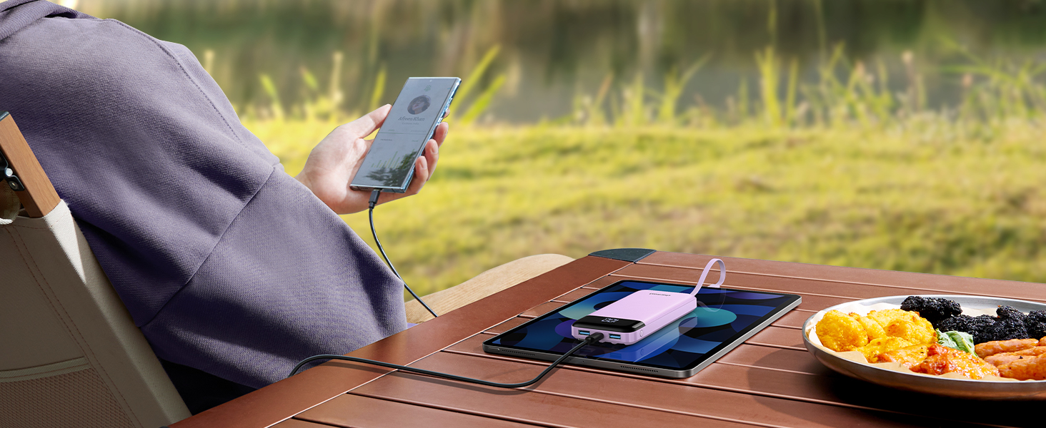 a person is using a smartphone to charge a charger on a table.