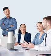 Group of people in business attire seated at a conference table with notebooks and a metallic cylinder-shaped device, likely an audio device, in the center.
