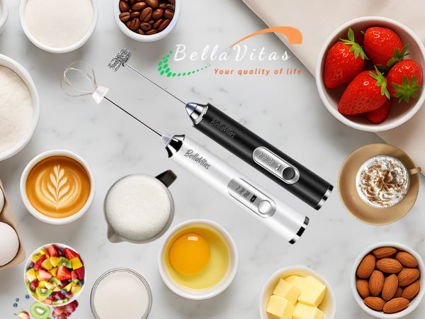 Black and white milk frothers with whisks on marble counter with coffee, milk, eggs, fruit