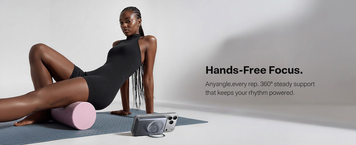 Woman on yoga mat uses phone with kickstand power bank.