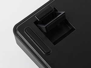 Close-up of a black plastic device corner with two square slots or ports visible.