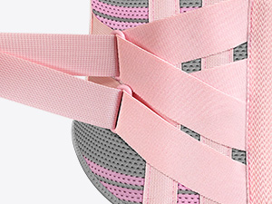 Close-up of pink sports equipment showing straps and mesh material detail with technical fastening system.