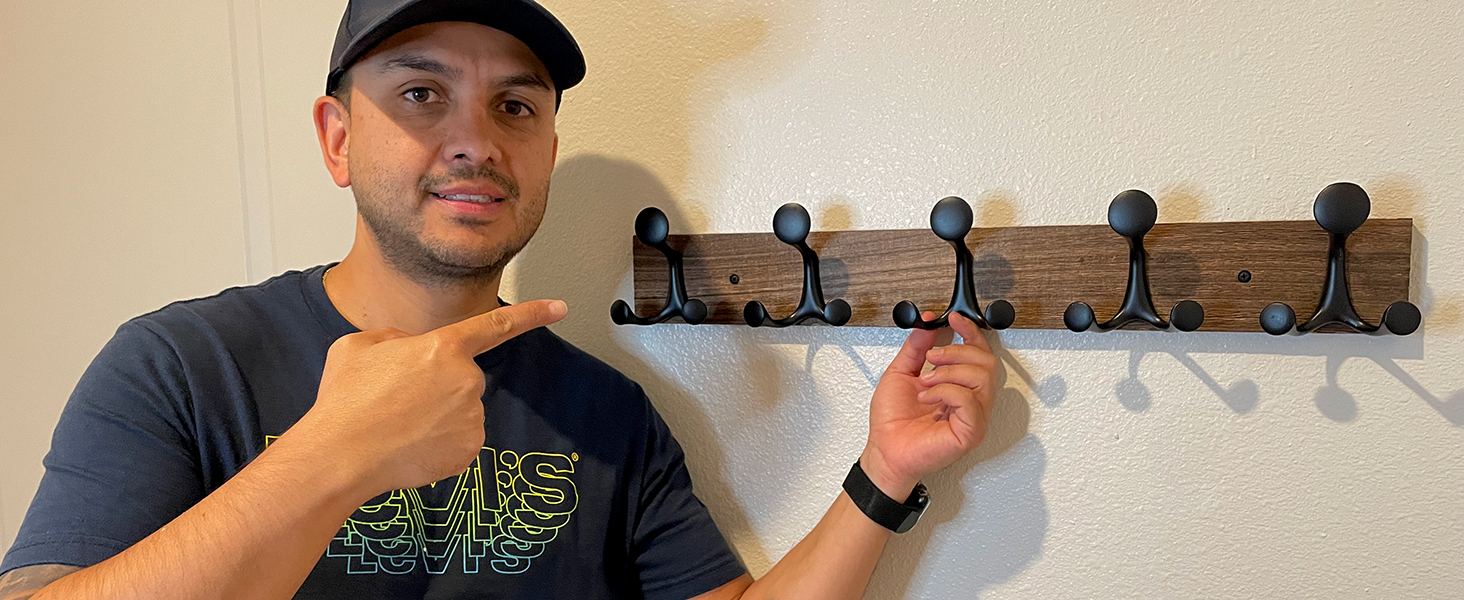 A man was very happy that this wooden brown coat rack at the entrance provided convenience.