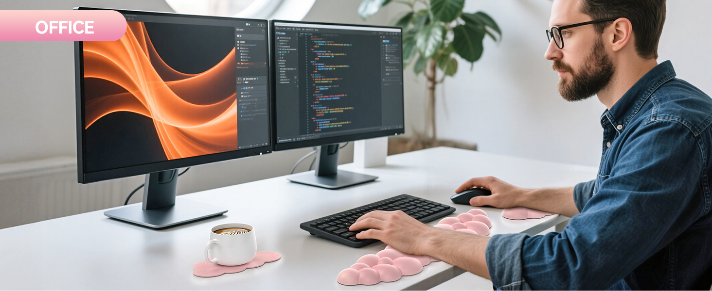 Dual-monitor computer setup on white desk. Man typing on keyboard. Screens show orange graphic and code. Coffee cup on pink coaster nearby.