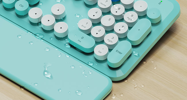 Water droplets on wireless keyboard and wrist rest showing splash resistant design easy wipe clean