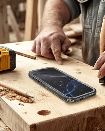 Rugged smartphone placed on wooden workbench surface, with carpenter's measuring tape visible in background.