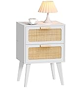 White wooden nightstand with two rattan-fronted drawers, tapered legs. Table lamp with pleated shade and coffee cup on top surface.