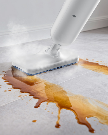 Steam mop cleaning tile floor in living room