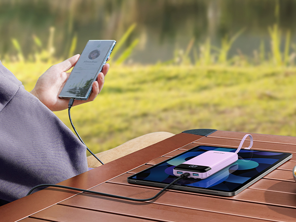 a person is using a smartphone to charge a charger on a table.