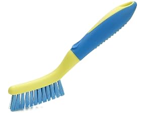 Cleaning brush with blue bristles, yellow-green ergonomic handle, and serrated edge on the reverse side. Dual-purpose design for scrubbing and scraping.