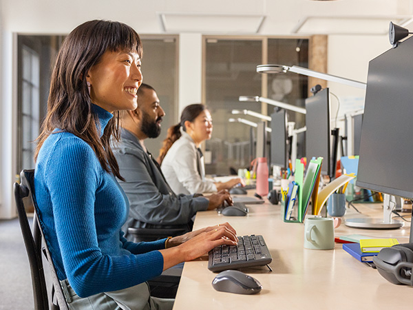 a woman using mk370 combo for business wireless keyboard and cordless mouse