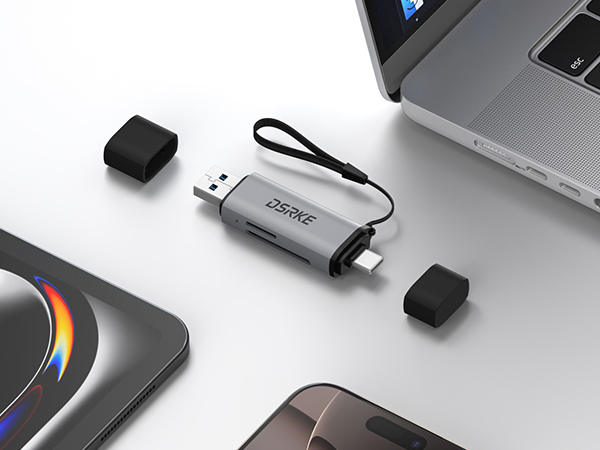 USB device with protective caps and cord shown between laptop and smartphone, alongside what appears to be a circular device with LED lighting.