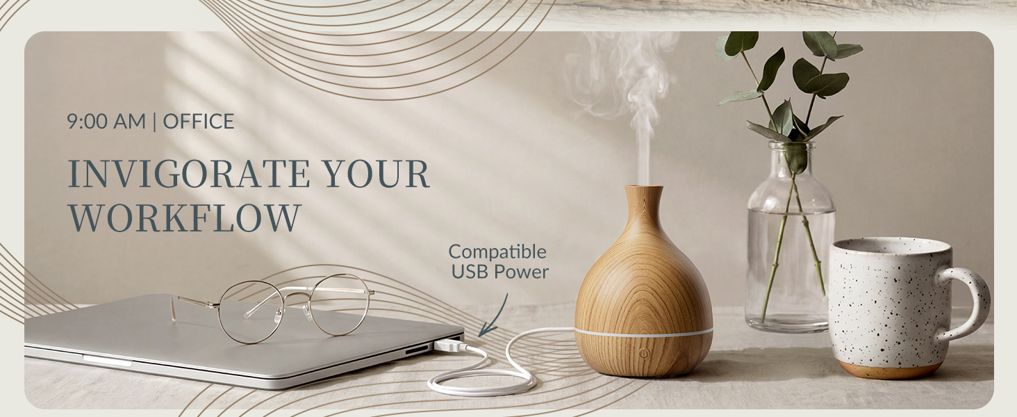 Wood grain vase essential oil diffuser on office desk connected to laptop via white USB power cable.