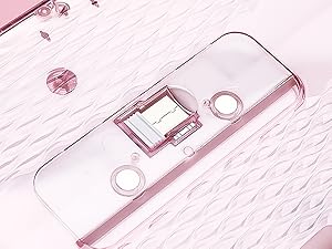 Close-up of a white digital device with LCD display screen and two circular buttons on either side, shown against a textured pink background.